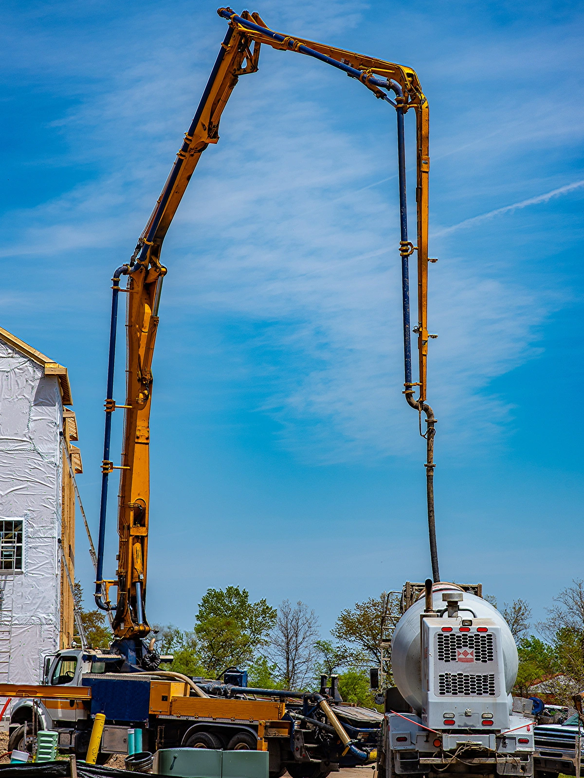 Camion pompe à béton avec bras articulé sur un chantier de construction